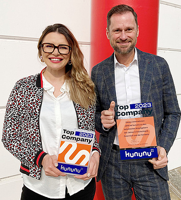 Ekaterina Chesnokova und Mario Schindlmayr posieren mit kununu-Auszeichnung