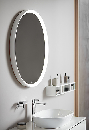 kreisrunder Spiegel an grauer Wand über weißem Waschbecken 