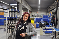 Sarah Berner lehnt auf Maschine in Fabrik 