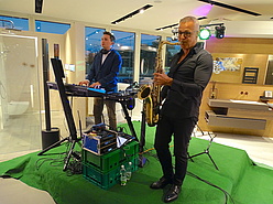Saxophonist und Keyboard-Spieler performen auf grüner Bühne