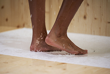 Füße auf nasser BetteAntirutsch Sense Oberfläche in weiß